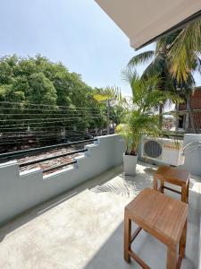 patio z ławką i stołem na balkonie w obiekcie Pineapple Surf Arugambay w mieście Arugam Bay