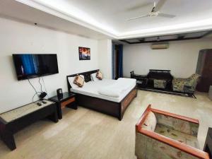 a bedroom with a bed and a flat screen tv at Taj Inn Residency in New Delhi
