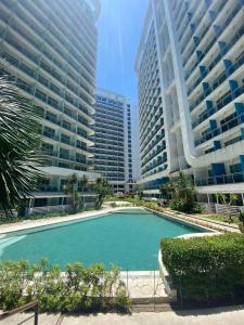 a swimming pool in front of two tall buildings at The Bahamas & Maldives Suites at Azure Residences near Manila Airport in Manila