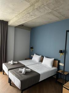 Hotel Citizen Avlabari في تبليسي: سريرين في غرفة نوم بجدران زرقاء