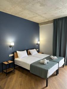 Hotel Citizen Avlabari في تبليسي: غرفة نوم عليها سرير وفوط