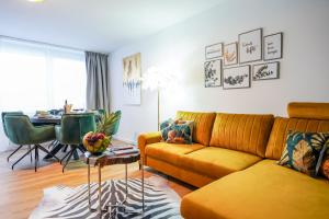 uma sala de estar com um sofá amarelo e uma mesa em CABANA City-Center - Küche - Netflix - Parkplatz em Oldenburg