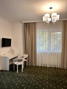 ein Hotelzimmer mit Schreibtisch und Fenster in der Unterkunft Vik-Jan in Chmelnyzkyj