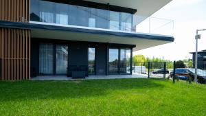 a glass building with a lawn in front of it at Laguna Beskidów, Sun & Snow in Zarzecze