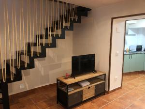 a living room with a tv and a staircase at Casa Puri in Jérica