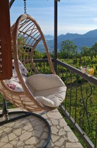 a wicker chair sitting on a balcony with a view at Banjo Rustic House Lake view in Virpazar