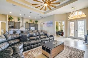 a living room with a leather couch and a table at Cape Coral Home on Lake with Heated Pool and Hot Tub! in Matlacha