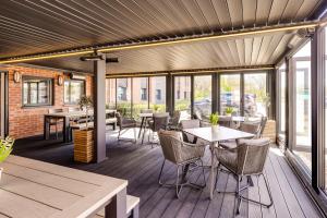 un patio avec des tables, des chaises et des fenêtres dans l'établissement ibis budget Derby, à Derby