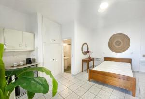 プラティスヤロス・シフノスにあるLemonia Rooms 1の白い部屋(ベッド1台、テーブル付)