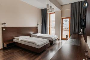 twee bedden in een kamer met houten vloeren bij Charlotte City Center Apartment in Košice