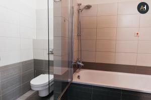コシツェにあるAH Charlotte City Center Apartmentのトイレ、浴槽、シャワー付きのバスルーム +16枚の写真
