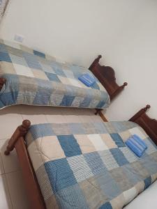 dos camas sentadas una al lado de la otra en una habitación en Departamento Temporario Rio Grande en Río Grande