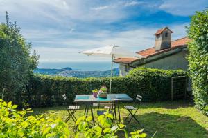 einen Tisch mit einem Regenschirm und Stühlen im Hof in der Unterkunft Casale In Vigna, CinqueTerreCoast in Casarza Ligure