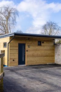 a large wooden garage with a large door at Midford Hideaway in Bath
