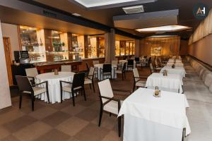 een restaurant met witte tafels en stoelen en een bar bij Charlotte City Center Apartment in Košice