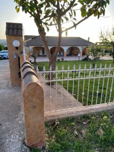 a fence in front of a house with a tree at The Arches House IUN F1092 in Alghero