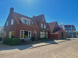 a large brick house with a bench in front of it at Strandhotel Domburg in Domburg