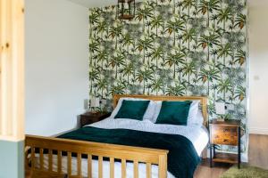 a bedroom with a bed with a floral wallpaper at Midford Hideaway in Bath