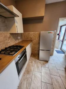 cocina con fogones y nevera blanca en Luton Airport - Affordable Home, en Luton