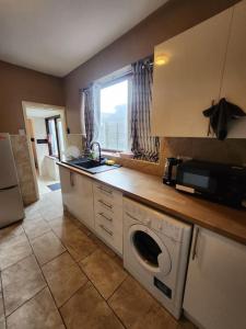 cocina con fregadero y lavadora en Luton Airport - Affordable Home, en Luton