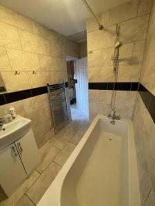 y baño con bañera y lavamanos. en Luton Airport - Affordable Home, en Luton