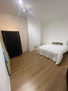 1 dormitorio con 1 cama y suelo de madera en Luton Airport - Affordable Home, en Luton