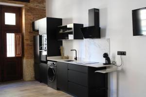 eine Küche mit einer Spüle, einem Herd und einem Kühlschrank in der Unterkunft Las Arenas Suites 1 PLAYA in Valencia