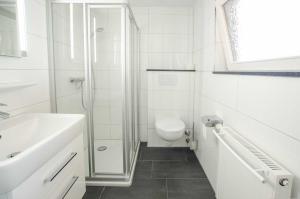 une salle de bains avec douche, toilettes et lavabo dans l'établissement FeWo Breuker, à Kellenhusen 3 autres photos