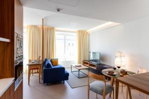 salon z niebieską kanapą i niebieskim krzesłem w obiekcie Oscar Concept Apartments w Lizbonie