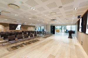 una sala de conferencias con filas de sillas y una pantalla de proyección en Novotel Paris Les Halles, en París