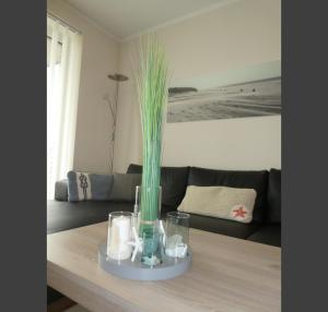 a living room with a table with a vase with grass at Quartier Hohe Geest 17 - Nord Seestern - a69854 in Cuxhaven