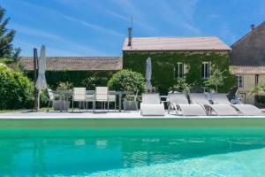 einen Pool mit Stühlen und Sonnenschirmen neben einem Haus in der Unterkunft Gite de charme Le Clos Michel 14 personnes piscine in Briord