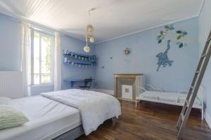ein blaues Schlafzimmer mit einem Bett und einer Leiter in der Unterkunft Gite de charme Le Clos Michel 14 personnes piscine in Briord