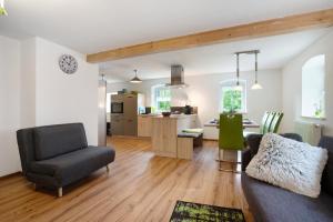 a living room with a couch and a kitchen at Ferienwohnungen 'am Waldrand' in Hartmannsbach