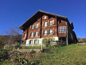 een groot houten huis bovenop een heuvel bij Dorengaden, 2-3 Bett Wohnung an ruhiger Lage mit Solarstrom in Grindelwald