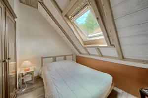 a bedroom with a bed and a skylight at La Nabias - Maison de montagne in Adervielle