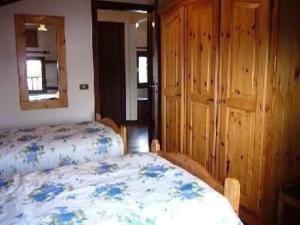um quarto com 2 camas, um espelho e uma cama em Schönes Ferienhaus in San Gregorio Nelle Alpi mit Grill und Terrasse em San Gregorio nelle Aloi