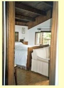 um quarto com uma cama e um sofá branco em Schönes Ferienhaus in San Gregorio Nelle Alpi mit Grill und Terrasse em San Gregorio nelle Aloi