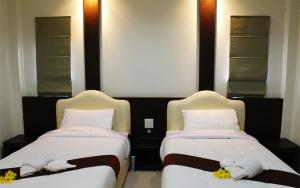 twee bedden naast elkaar in een kamer bij Saabpaiboon Grand Resort in Ban Talat