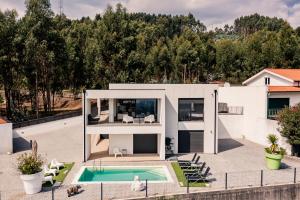 uma casa com uma piscina em frente em Villa Paoryna em Vila Verde