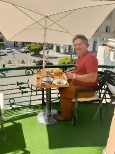 un hombre sentado en una mesa con un plato de comida en Cairo Inn, en El Cairo