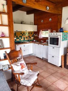 イトリにあるChalet Mimosaのキッチン(白いキャビネット、椅子、コンロ付)