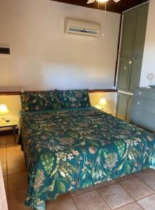 イトリにあるChalet Mimosaのベッドルーム1室(ベッド1台、緑の毛布付)