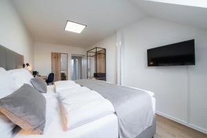 Hotel LEON في براغ: غرفة نوم مع سرير أبيض كبير مع تلفزيون بشاشة مسطحة