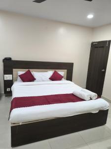 a bedroom with a large bed with red pillows at archana GRAND in Visakhapatnam