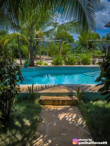 einen Pool in einem Resort mit einer Palme in der Unterkunft Tofauti Inn in Makunduchi