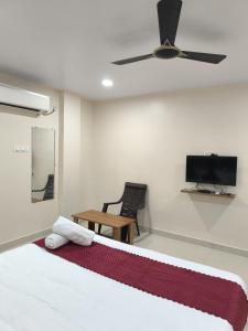 um quarto com uma cama e uma ventoinha de tecto em archana GRAND em Visakhapatnam