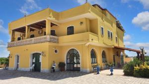 a yellow building with a balcony on top of it at One bedroom bungalow with shared pool and wifi at Lizzano 6 km away from the beach in Lizzano