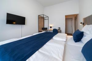 Hotel LEON في براغ: غرفة نوم مع سرير كبير وتلفزيون على الحائط