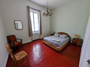 um quarto com uma cama, uma cadeira e uma janela em Maison de style tout confort, position idéale, avec clim et petit extérieur em Orange